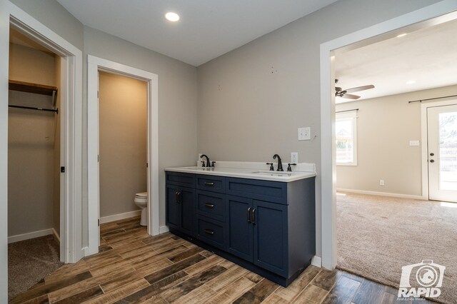 bathroom featuring a sink, toilet, and wood finished floors