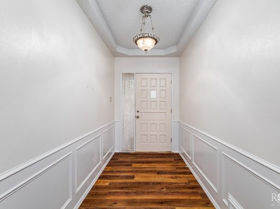 3309 Cedarhill Dr, San Angelo, TX 76904 - entryway featuring a decorative wall, wainscoting, dark wood finished floors, and a tray ceiling