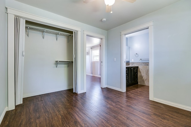 unfurnished bedroom with a closet, wood finished floors, baseboards, and ceiling fan