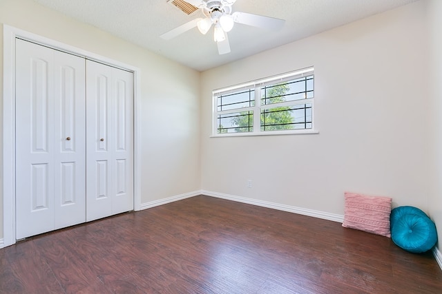 unfurnished bedroom with wood finished floors, baseboards, a closet, and a ceiling fan