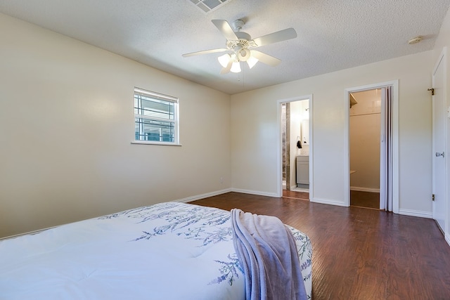 bedroom with wood finished floors, a textured ceiling, baseboards, a ceiling fan, and ensuite bath