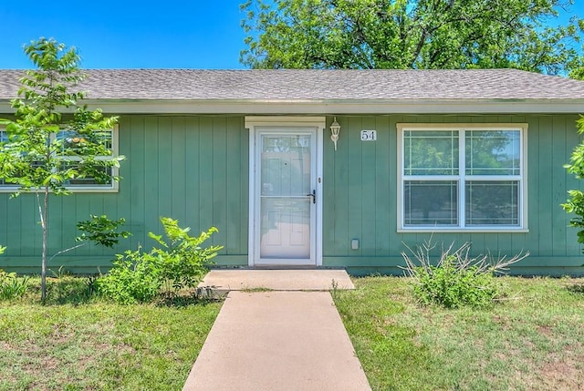 54 E 8th St, San Angelo, TX 76903 - property entrance with a shingled roof and a lawn