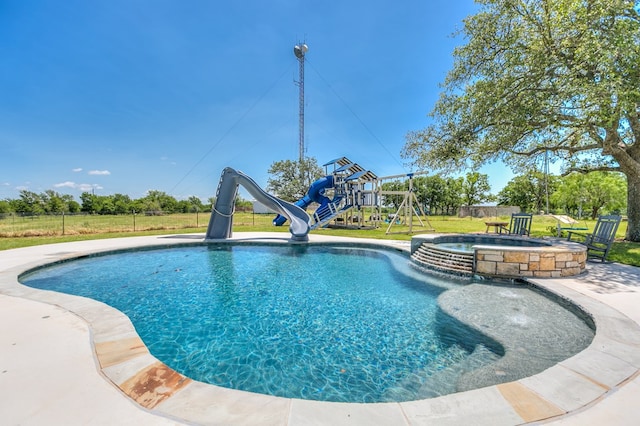 view of pool with a playground, an in ground hot tub, a water slide, and a yard