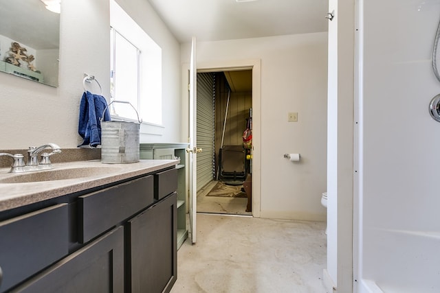 bathroom with vanity, concrete floors, and toilet