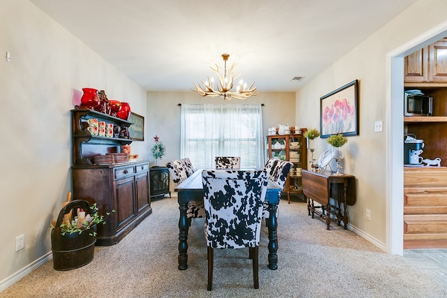 dining area with light colored carpet and a chandelier