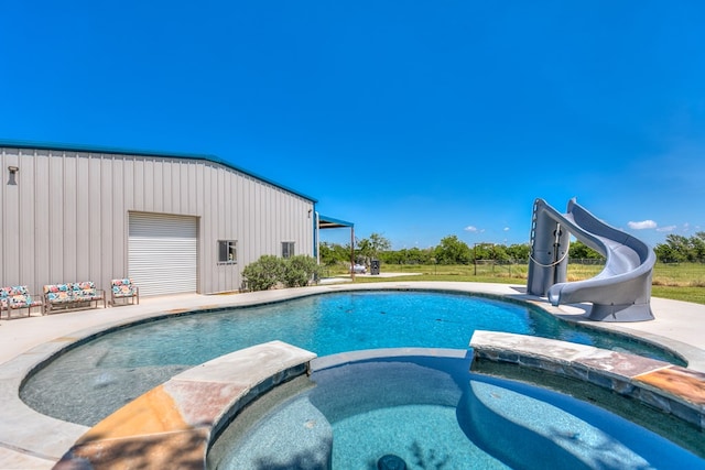 view of pool featuring an in ground hot tub and a water slide