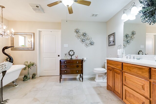 bathroom featuring vanity, toilet, ceiling fan with notable chandelier, and a bathtub