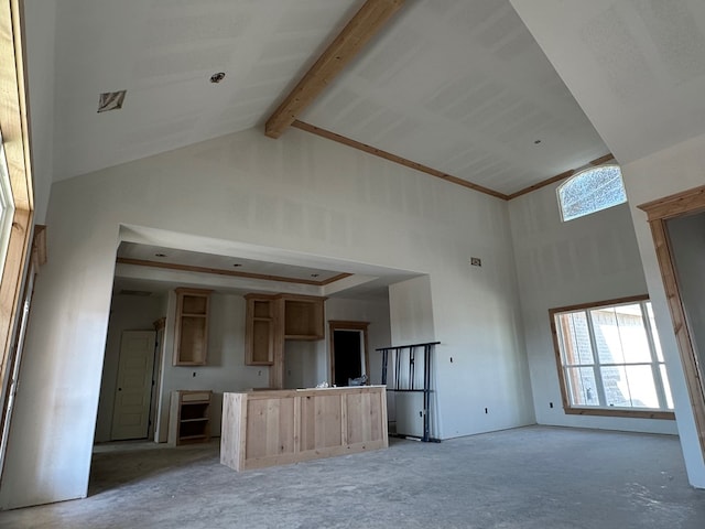 unfurnished living room featuring beam ceiling and high vaulted ceiling