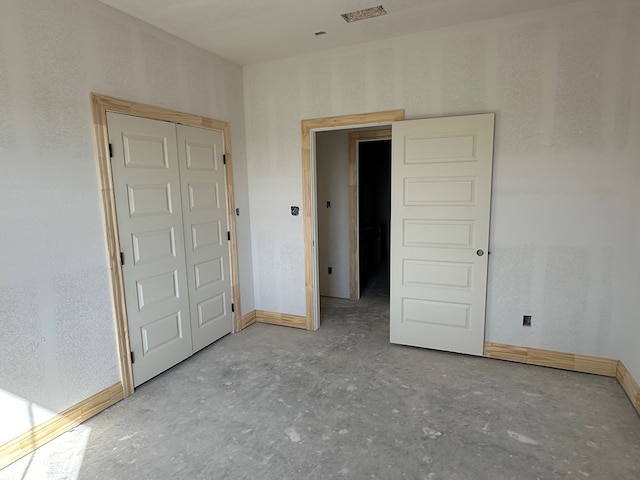 unfurnished bedroom with a closet and baseboards