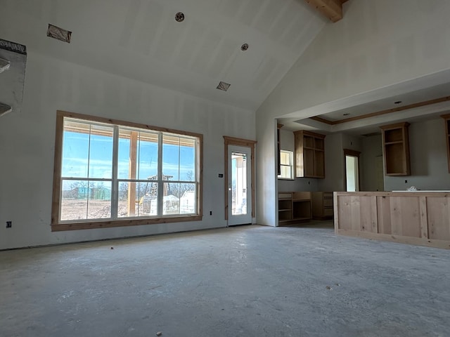 unfurnished living room with high vaulted ceiling