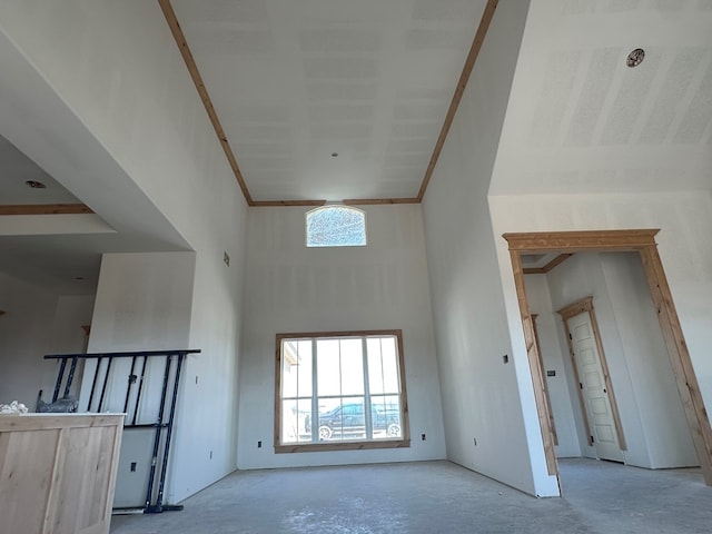 unfurnished room featuring crown molding and a towering ceiling