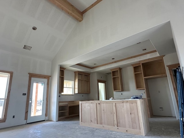 kitchen with high vaulted ceiling, a center island, and open shelves