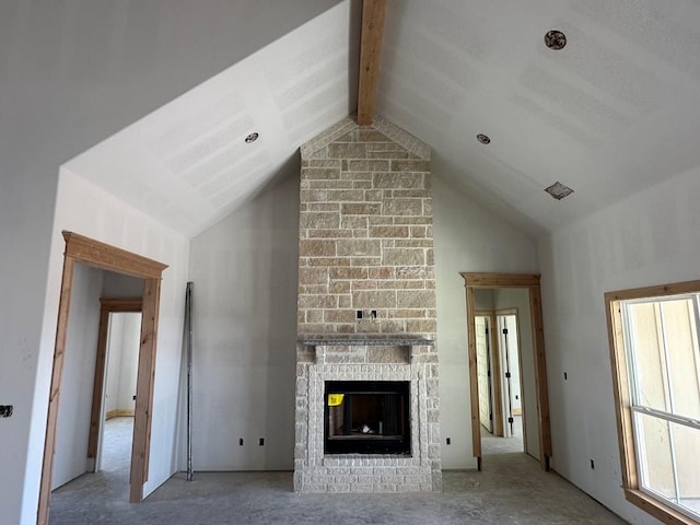 unfurnished living room featuring beamed ceiling, high vaulted ceiling, and a large fireplace