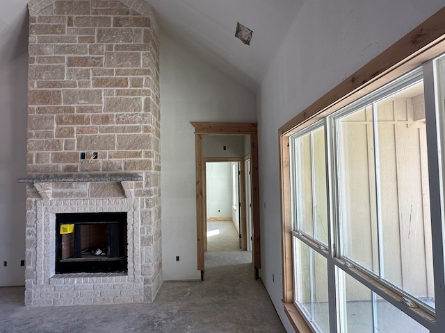 unfurnished living room with a fireplace and high vaulted ceiling