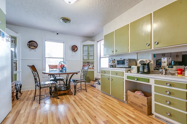 kitchen featuring a healthy amount of sunlight, a textured ceiling, and green cabinetry