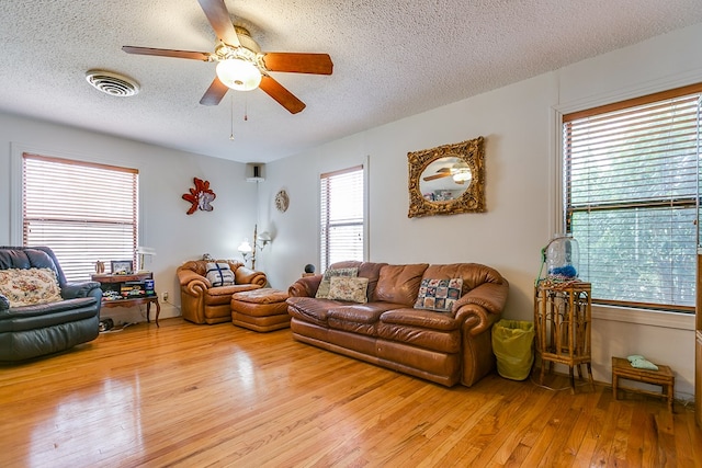 living room with a textured ceiling and light wood-type flooring