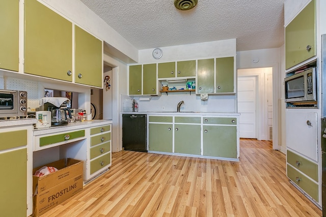 kitchen with green cabinetry, black dishwasher, sink, and a textured ceiling