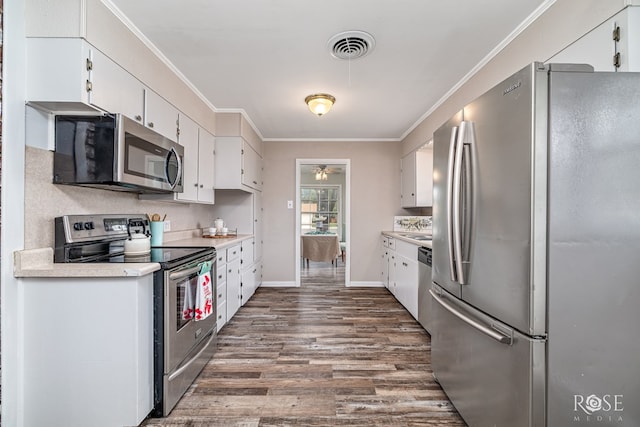 1902 College Hills Blvd, San Angelo, TX 76904 - kitchen with appliances with stainless steel finishes, dark wood-type flooring, white cabinets, and crown molding