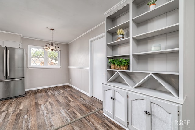 1902 College Hills Blvd, San Angelo, TX 76904 - unfurnished dining area with dark wood finished floors, a chandelier, crown molding, baseboards, and a wainscoted wall