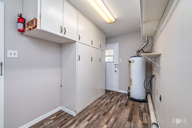 1902 College Hills Blvd, San Angelo, TX 76904 - laundry room featuring water heater, dark wood-style flooring, cabinet space, and baseboards