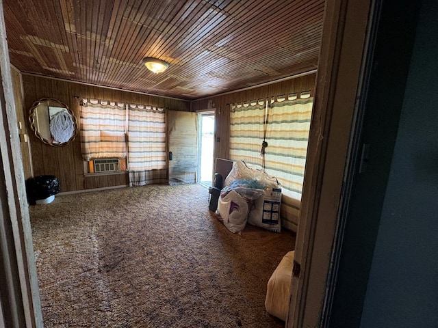 interior space featuring wooden ceiling, wood walls, and carpet