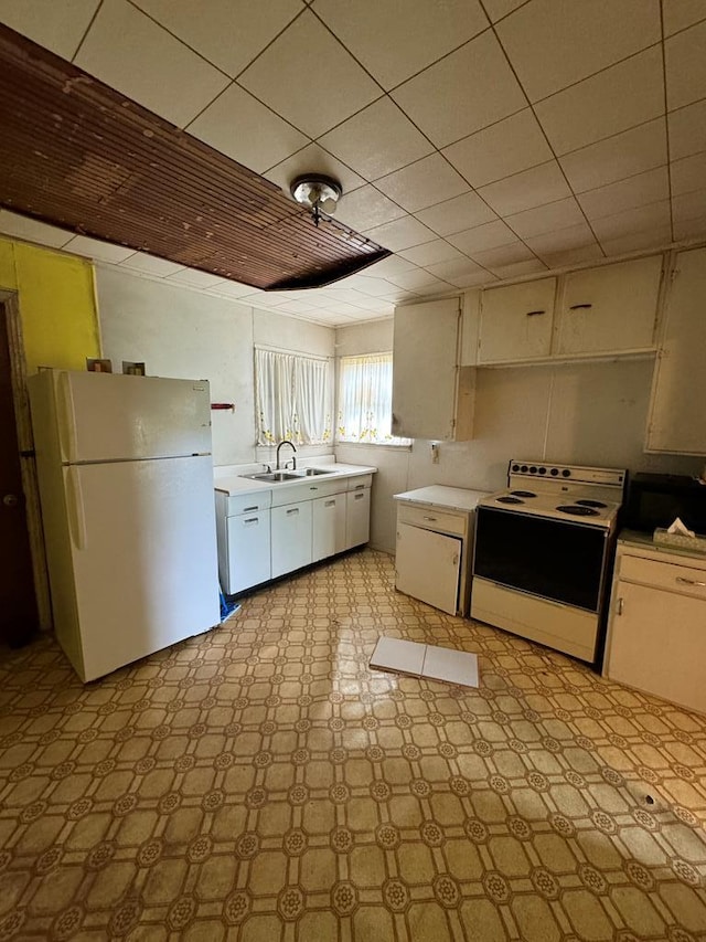 kitchen featuring white appliances, sink, and white cabinets