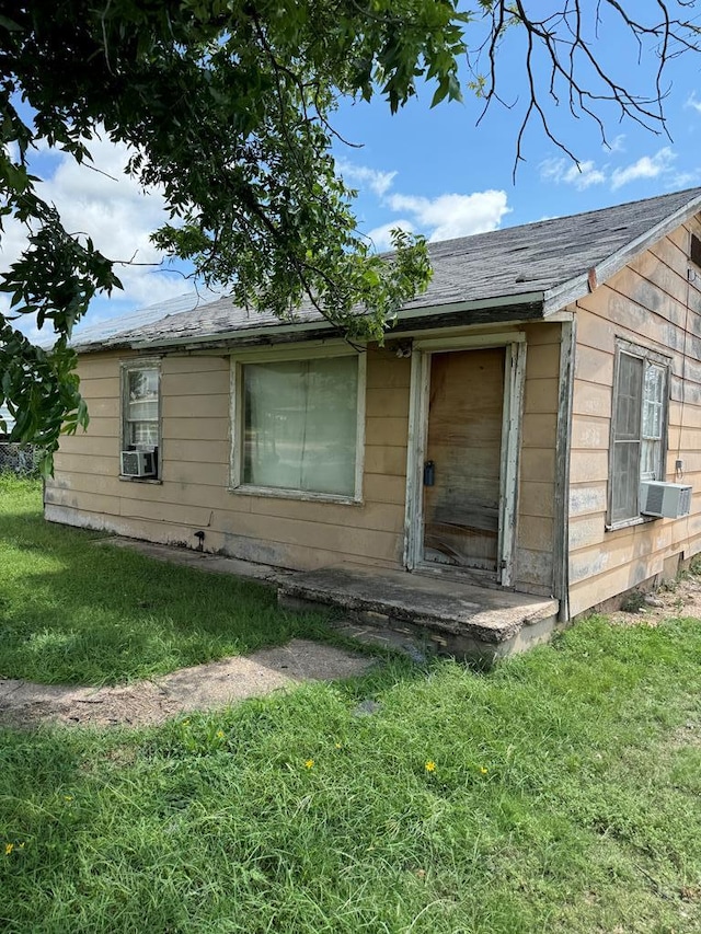 view of side of property with cooling unit and a yard