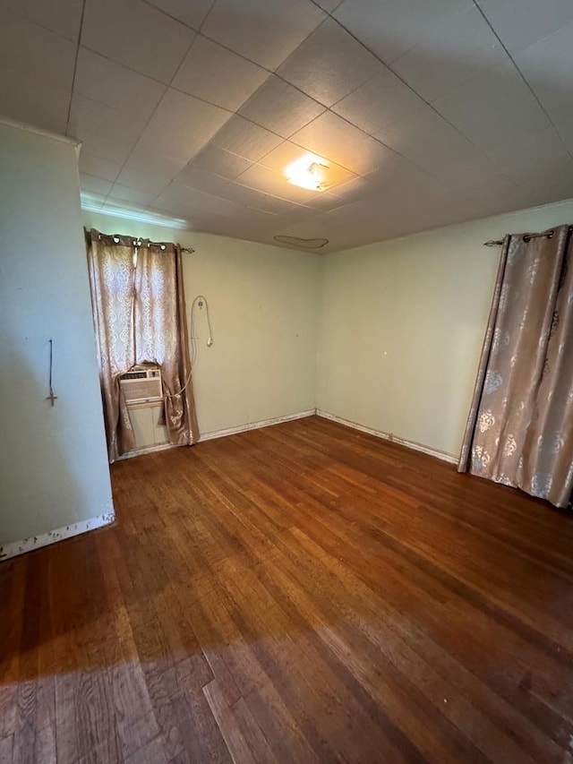 spare room featuring cooling unit and hardwood / wood-style floors