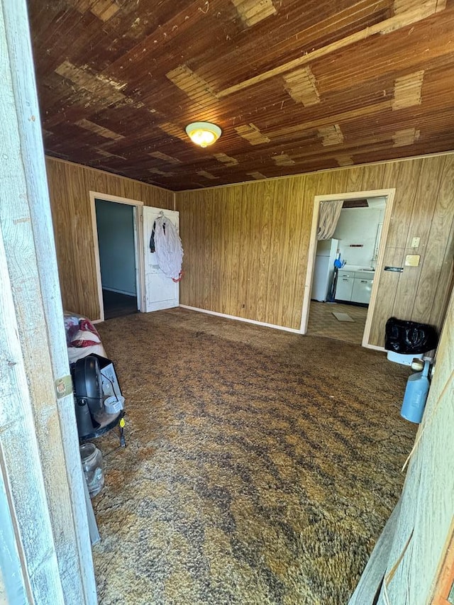 additional living space with wooden walls, wood ceiling, and dark carpet