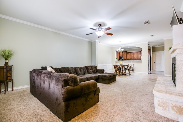 living room with ornamental molding, light colored carpet, and ceiling fan with notable chandelier