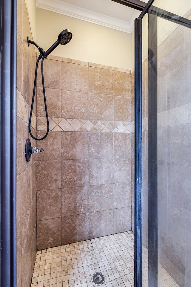 bathroom featuring crown molding and a tile shower