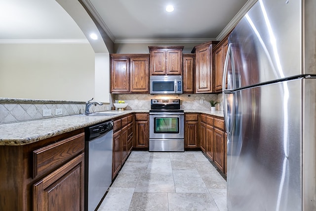 kitchen with appliances with stainless steel finishes, decorative backsplash, light stone countertops, and kitchen peninsula