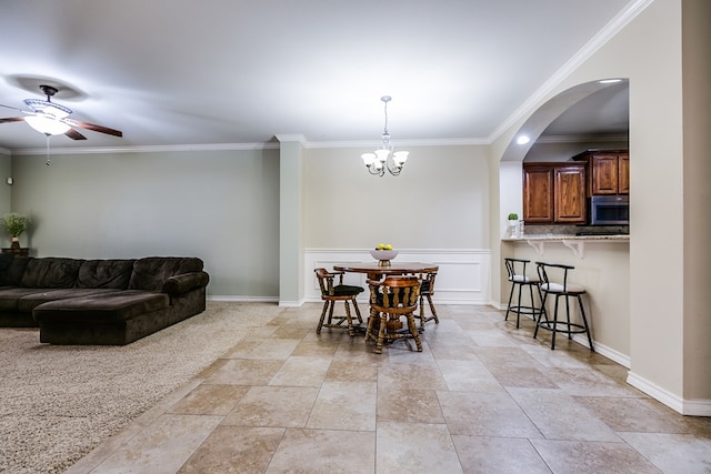 dining area featuring ceiling fan with notable chandelier and crown molding