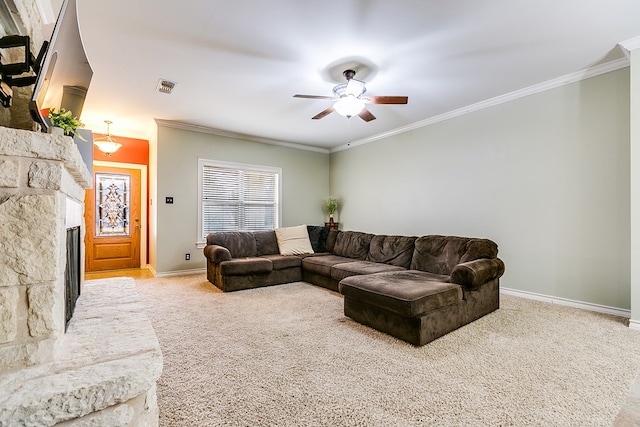 living room featuring ceiling fan, carpet flooring, crown molding, and a stone fireplace