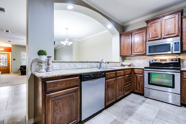 kitchen featuring crown molding, appliances with stainless steel finishes, light stone countertops, and backsplash