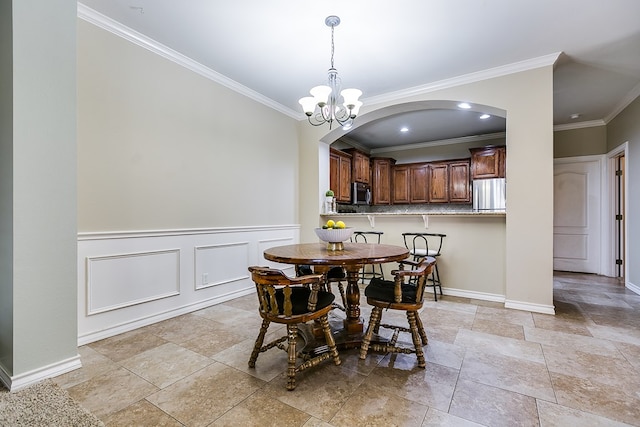 dining room with crown molding and an inviting chandelier