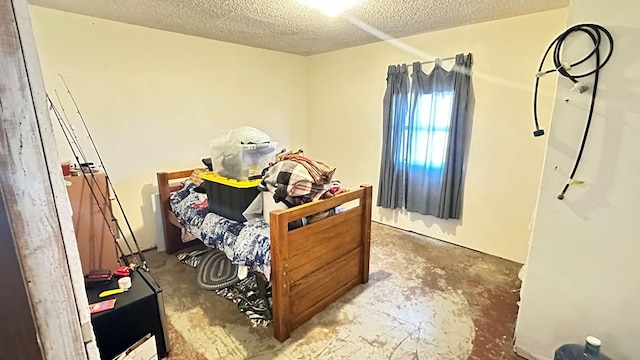 bedroom with concrete flooring and a textured ceiling