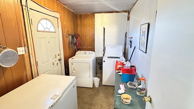 clothes washing area with wooden walls and washer and dryer