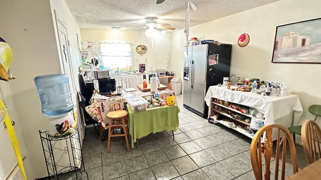 kitchen featuring ceiling fan, tile patterned flooring, stainless steel fridge with ice dispenser, and a textured ceiling