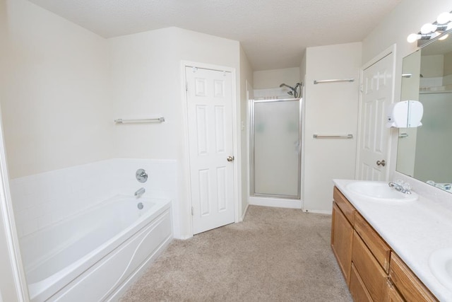4206 Pinon Ridge Dr, San Angelo, TX 76904 - bathroom featuring a stall shower, a bath, double vanity, carpet flooring, and a textured ceiling