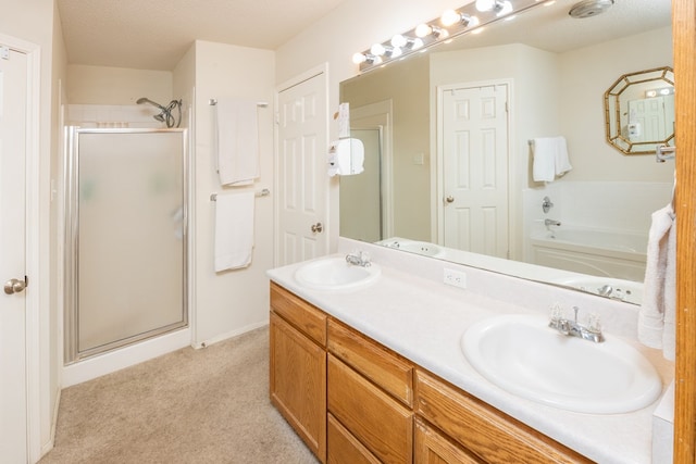 bathroom featuring a sink, double vanity, a stall shower, and a garden tub