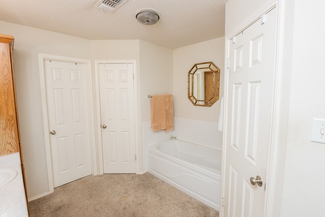 full bathroom with visible vents, a textured ceiling, carpet floors, and a bath