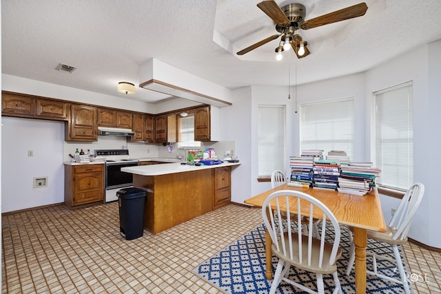 kitchen with ceiling fan, kitchen peninsula, a textured ceiling, and white range with electric stovetop