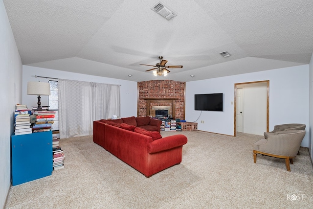 living room featuring lofted ceiling, carpet floors, a fireplace, and ceiling fan