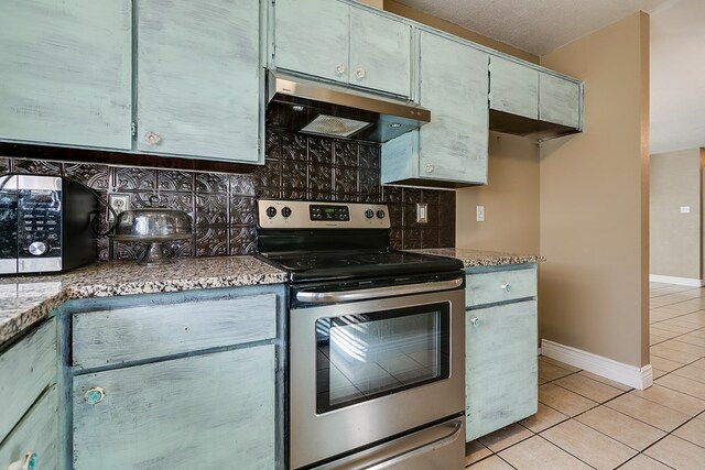 3101 Grove Dr, San Angelo, TX 76903 - kitchen featuring appliances with stainless steel finishes, under cabinet range hood, light tile patterned flooring, and decorative backsplash