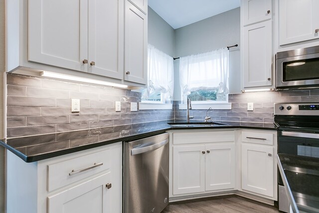 3406 Twin Mountain Dr, San Angelo, TX 76904 - kitchen featuring stainless steel appliances, white cabinetry, tasteful backsplash, and wood finished floors