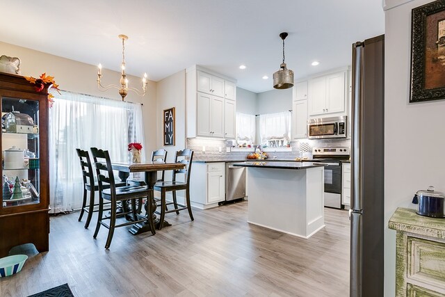 3406 Twin Mountain Dr, San Angelo, TX 76904 - kitchen featuring appliances with stainless steel finishes, a chandelier, tasteful backsplash, white cabinets, and light wood-type flooring