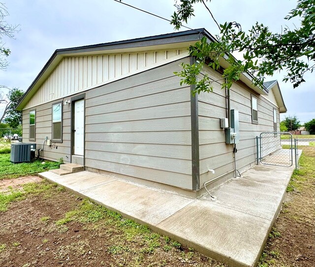 919 E 20th St, San Angelo, TX 76903 - view of property exterior with a gate, central AC unit, and board and batten siding