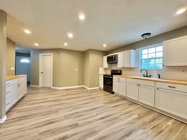 919 E 20th St, San Angelo, TX 76903 - kitchen with appliances with stainless steel finishes, light wood-style flooring, a sink, white cabinetry, and recessed lighting