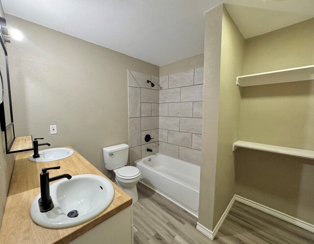 919 E 20th St, San Angelo, TX 76903 - bathroom with wood finished floors, toilet, double vanity, and  shower combination